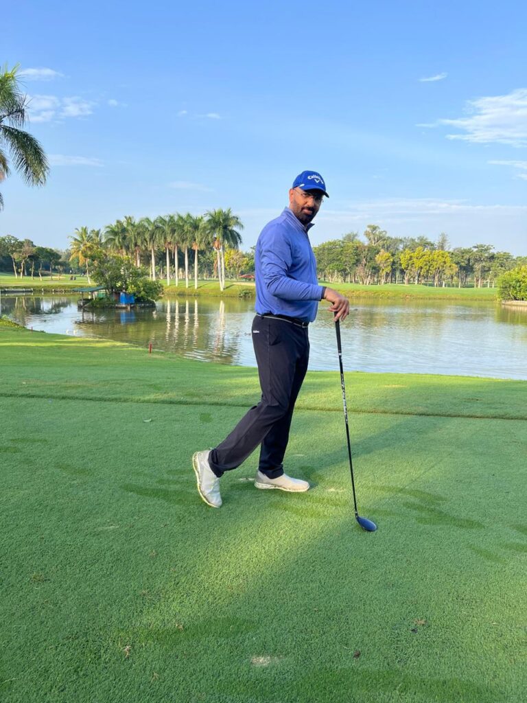 Govind Raj on a golf course with a club beside a lake