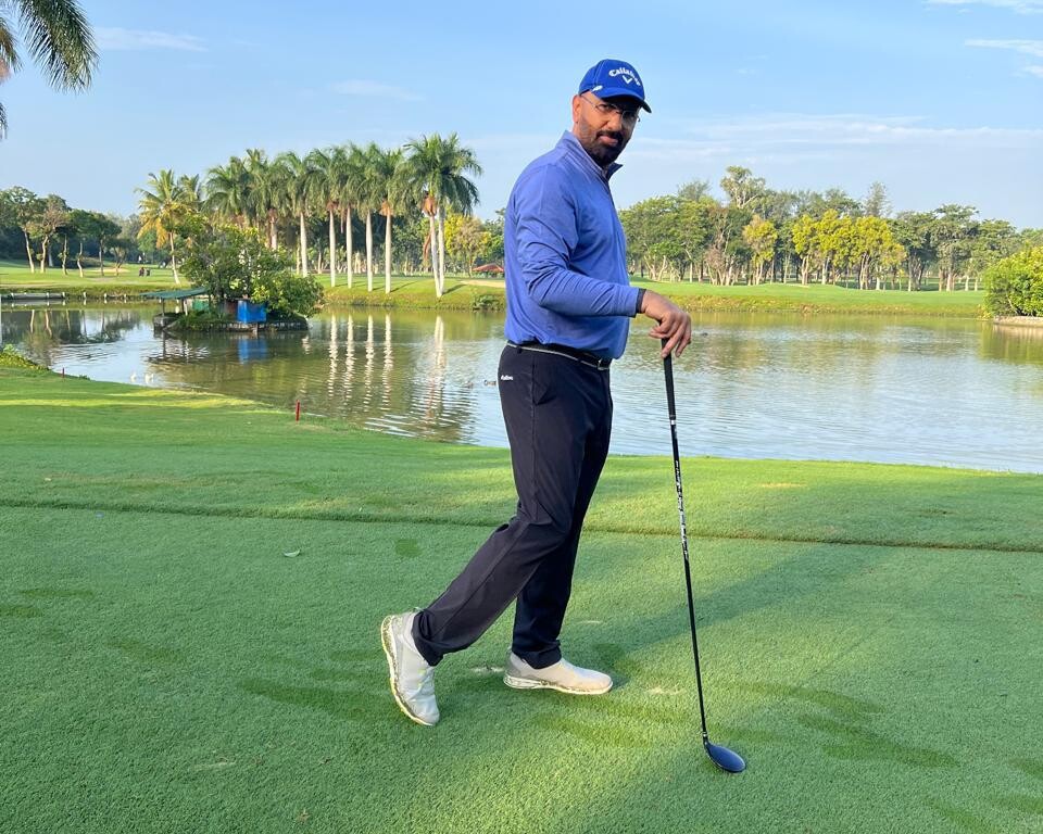 Govind Raj on a golf course with a club beside a lake