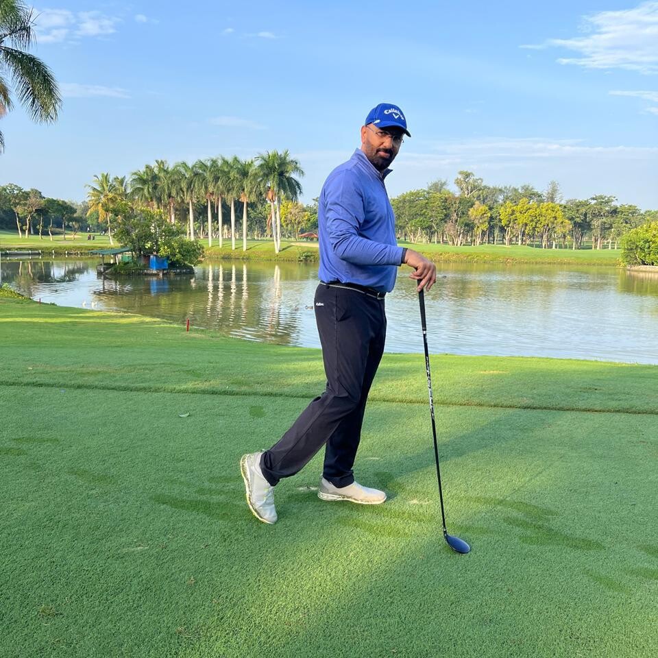 Govind Raj on a golf course with a club beside a lake
