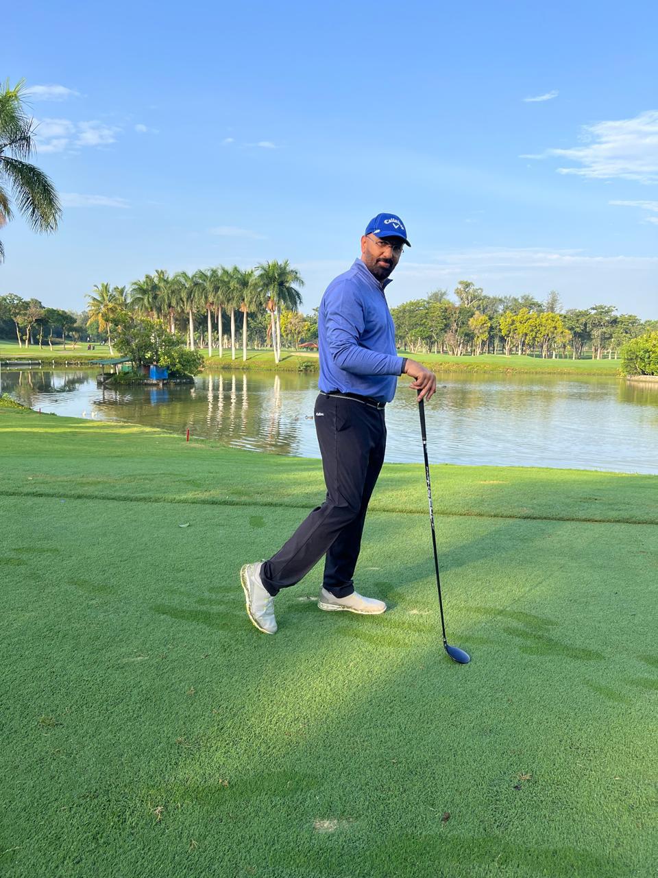 Govind Raj on a golf course with a club beside a lake